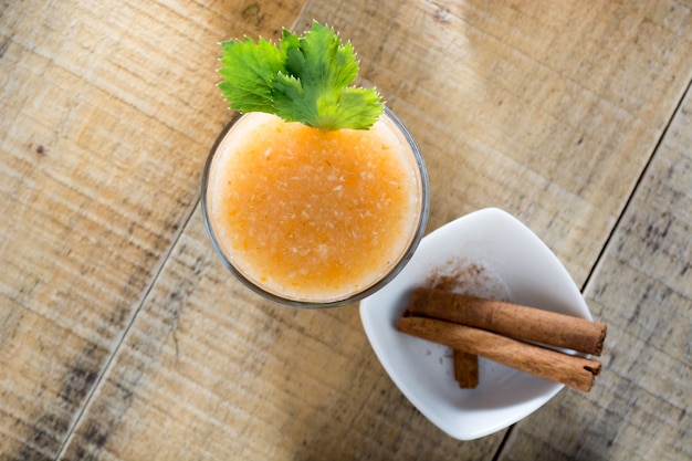 Boisson saine au gingembre servie avec des bâtons de cannelle