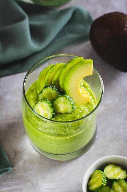 Photo boisson saine à base de concombres et d'avocats dans un verre sur la table vue verticale