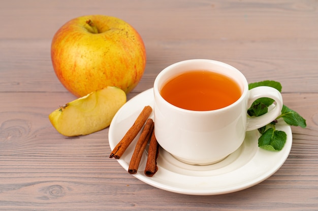 Boisson de thé aux pommes servi sur table en bois close up