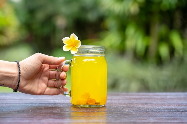 Boisson tonique énergétique au curcuma gingembre citron et miel dans une tasse en verre nature background close up