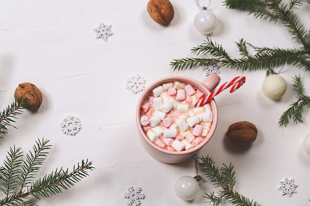 Boissons chaudes de Noël cacao d'hiver avec des guimauves et des branches d'épinette sur fond blanc