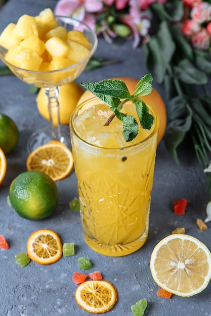 Boissons fraîches d'été. Limonade glacée dans la cruche et citrons et orange à la menthe sur la table en plein air. Limonade orange dans un verre.