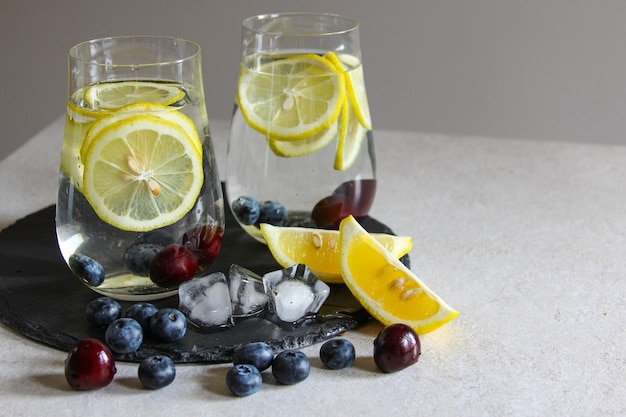 Boissons fraîches en petites bouteilles Cerises et limonade au citron Cocktail Mojito Rafraîchissement glacé d'été