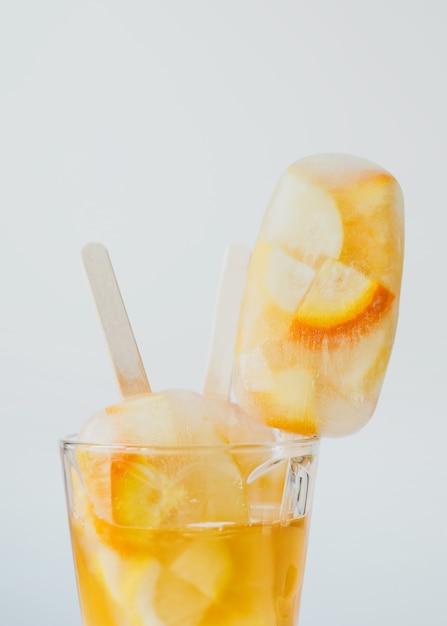 Boissons froides d'été cocktail d'agrumes orange et citron avec glace et sucettes glacées sur bâton