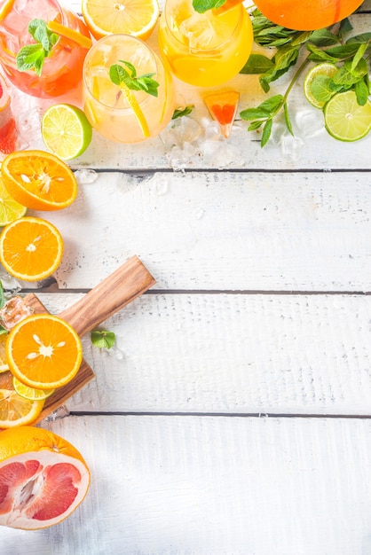 Photo boissons froides d'été, cocktail de sangria à la limonade aux fruits, boissons infusées avec divers agrumes - orange, citron, pamplemousse, citron vert, avec espace de copie de fruits frais