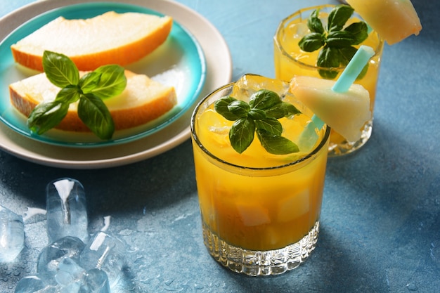 Boissons rafraîchissantes et jus d'agrumes avec glaçons, menthe et melon. Concept d'été