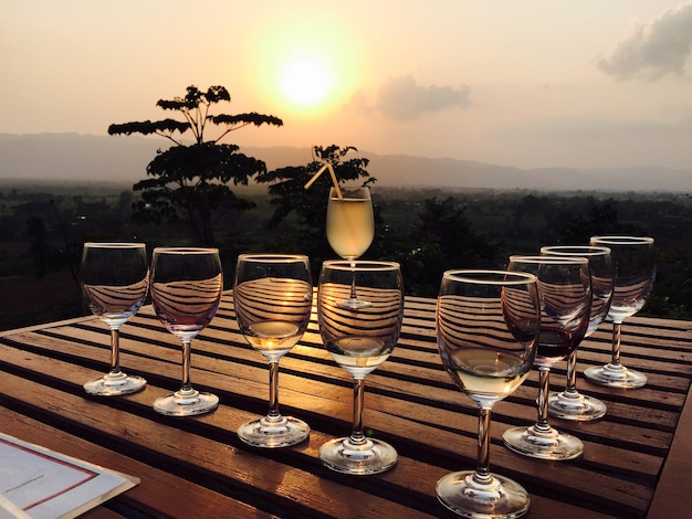 Des boissons sur la table contre le ciel au coucher du soleil