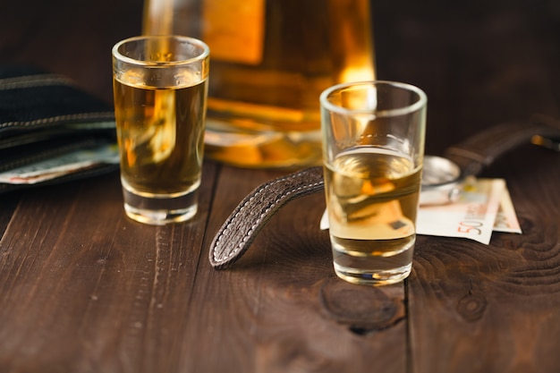 Boissons de week-end sur table, verre avec de l'eau-de-vie et de l'argent sur la table