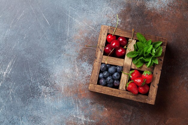 Boîte de baies fraîches d'été Cerise myrtille fraise et menthe Vue de dessus avec espace pour votre texte