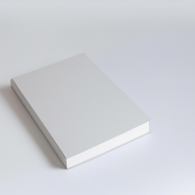 Une boîte blanche avec un couvercle blanc se trouve sur une surface blanche.