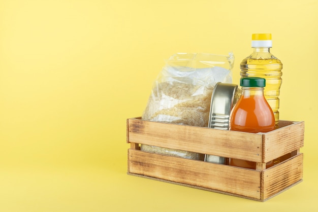 Boîte en bois avec des aliments en conserve et des bouteilles