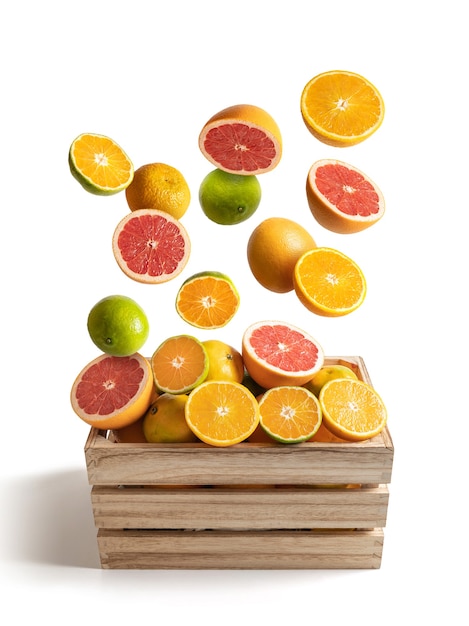 Boîte en bois d'un assortiment d'oranges et de mandarines volant, isolé du blanc