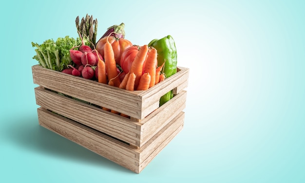 Boîte en bois avec des légumes frais isolés