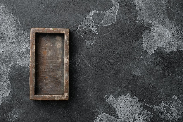 Boîte en bois sombre vide avec espace de copie pour le texte ou la nourriture, vue de dessus à plat, sur fond de table en pierre noire foncée