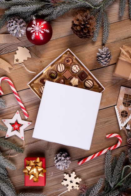 Boîte de bonbons au chocolat de Noël sur une table en bois avec décoration saisonnière