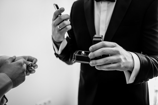 boîte avec boutons de manchette. Un homme en chemise blanche, tenant une boîte avec des boutons de manchette. photographie en noir et blanc