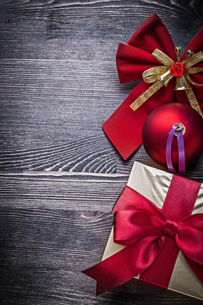 Boîte-cadeau d'arc de boule scintillante de Noël sur planche de bois