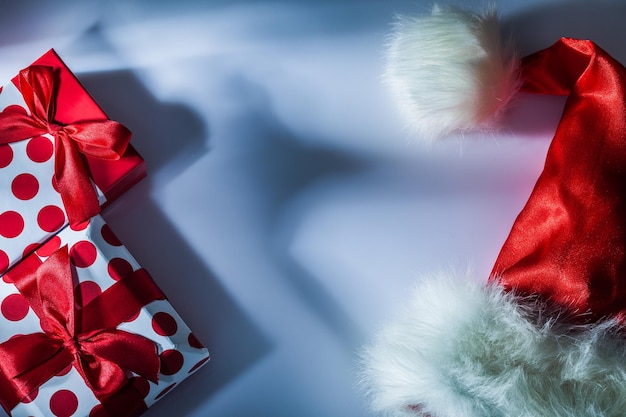 Boîte-cadeau emballée par chapeau rouge de Santa sur le fond blanc