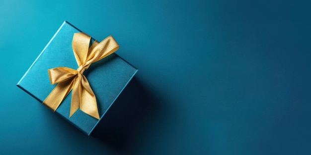 Boîte cadeau luxueuse en or avec ruban sur fond bleu