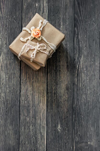 Une boîte cadeau marron avec un ruban et une fleur dessus