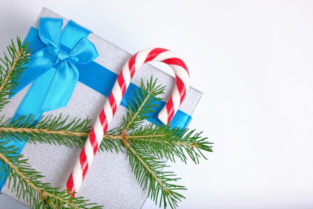 Boîte-cadeau de Noël attachée avec un ruban bleu avec un arc avec un sapin de Noël vert et du caramel