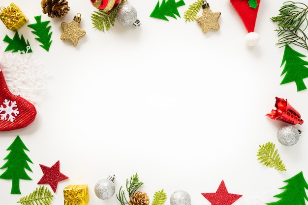 Boîte de cadeau de Noël avec boule rouge et pommes de pin sur fond blanc.