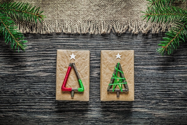 Boîte de cadeau de Noël de branche de pin de toile de jute vintage sur planche de bois