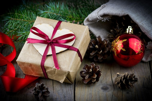 Photo boîte de cadeau de noël avec des branches de sapin et des cônes de pin