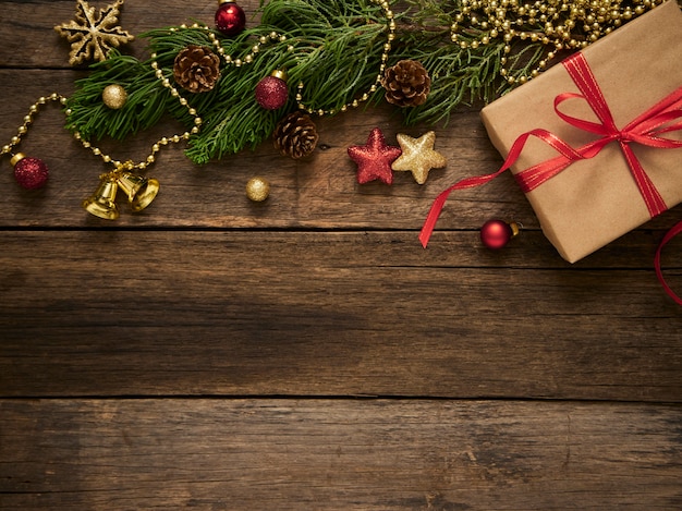 Boîte-cadeau de Noël avec des branches de sapin et des décorations sur fond de bois foncé rustique