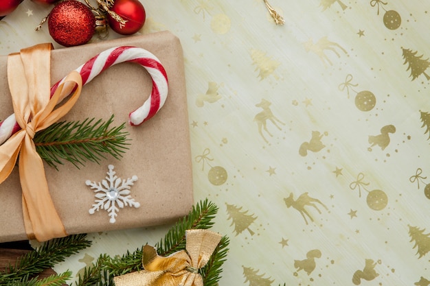 Boîte de cadeau de Noël, décor de nourriture et branche de sapin sur une table en bois. Vue de dessus avec fond