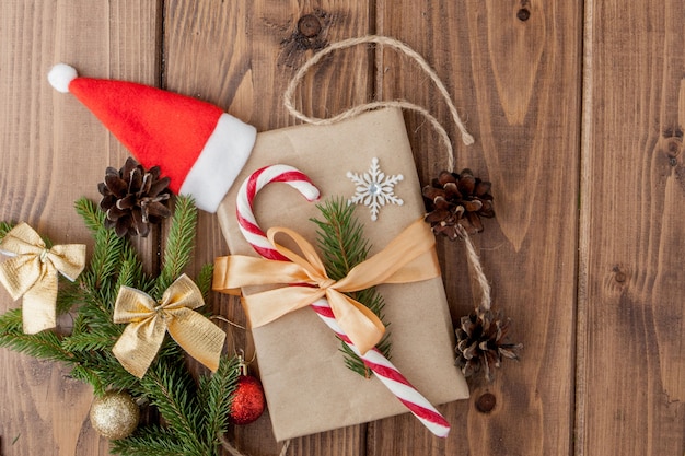 Boîte de cadeau de Noël, décor de nourriture et branche de sapin sur une table en bois. Vue de dessus avec fond