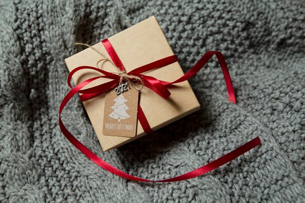 boîte-cadeau de Noël se trouve sur un pull en tricot gris