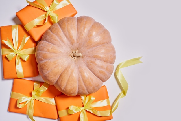 Boîte-cadeau orange et citrouille sur cadeau de Thanksgiving blanc et citrouille fraîchement récoltée sur fond blanc...