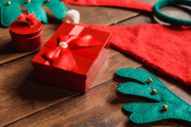 Boîte-cadeau rouge et bonnet de noel sur bois