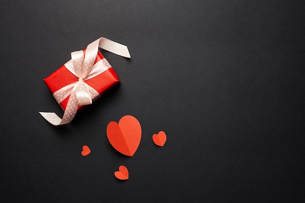 Boîte-cadeau Saint Valentin avec des coeurs rouges sur fond de papier noir