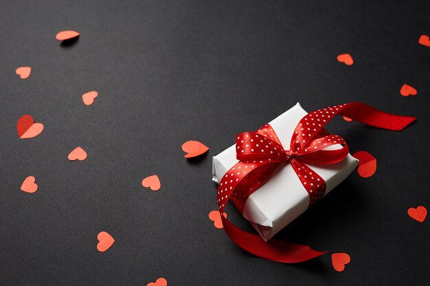 Boîte-cadeau Saint Valentin avec des coeurs rouges sur fond de papier noir