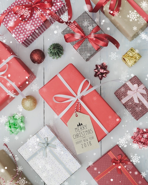 Boîte de cadeau de vacances de Noël et du nouvel an sur la table en bois blanche avec l&#39;effet de chute de neige. Étendre avec le signe de joyeux Noël et de bonne année 2018. Concept de cadeaux et de félicitations.