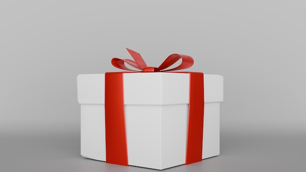 une boîte à cadeaux blanche avec un ruban rouge attaché autour d'elle