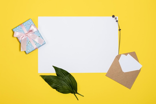 Photo une boîte à cadeaux en enveloppe blanche sur un fond jaune