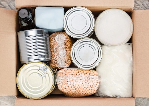 Boîte en carton avec aliments en conserve et céréales sucrées produits à longue durée de conservation vue de dessus