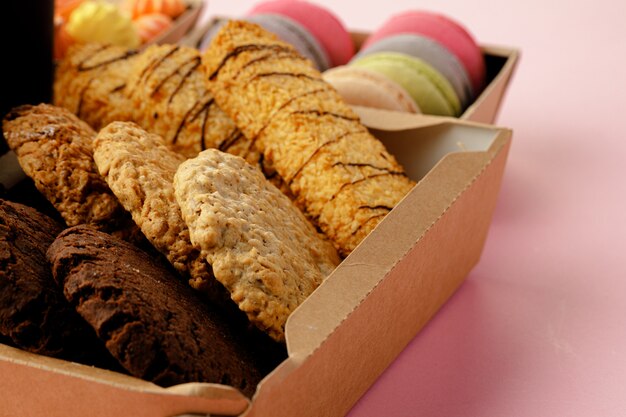 Boîte en carton avec des biscuits à l'avoine sur table rose