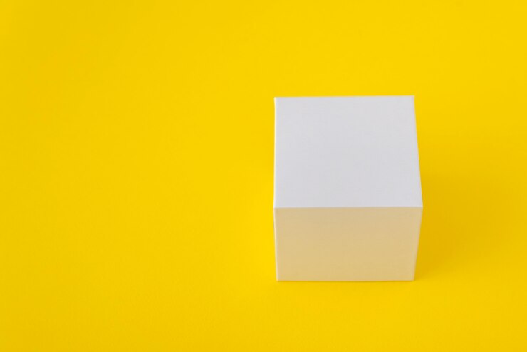 Photo boîte en carton carré blanc sur jaune