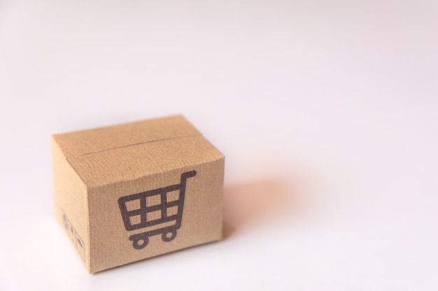 Boîte en carton ou colis avec logo chariot de supermarché sur fond blanc. avec espace de copie