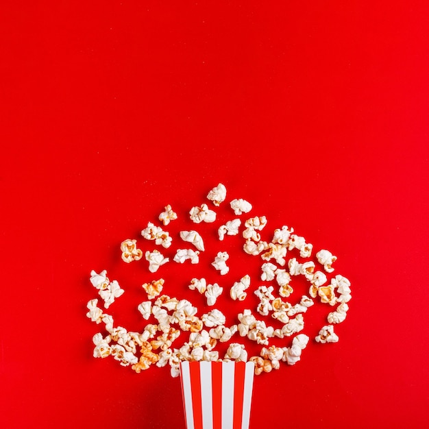 boîte en carton avec du pop-corn sur un fond rouge en gros plan