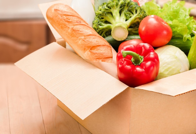 Boîte en carton avec épicerie sur une table en bois