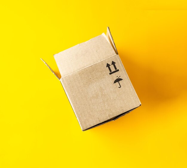 boîte en carton ouverte sur fond jaune en gros plan