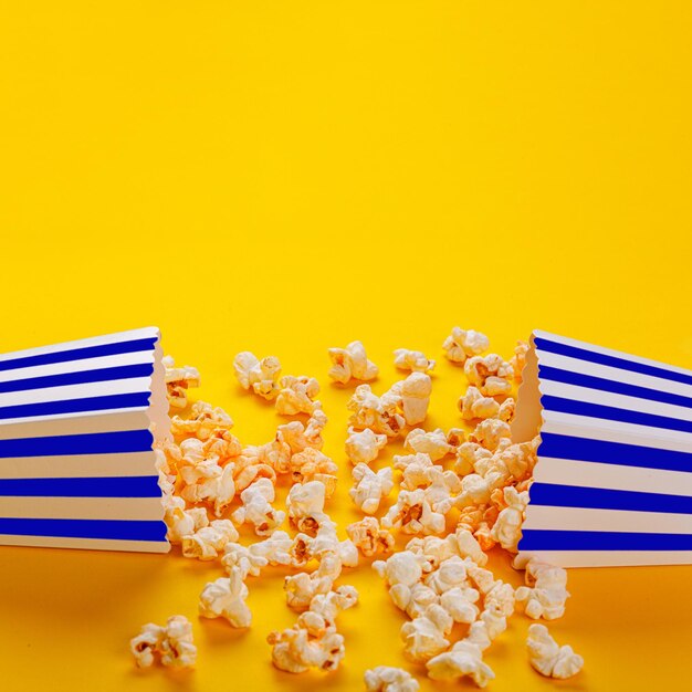 boîte en carton avec pop-corn sur fond jaune gros plan