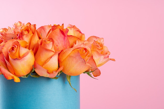 Boîte en carton avec roses sur fond rose