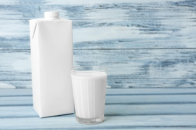 Boîte en carton et verre de lait sur fond de bois