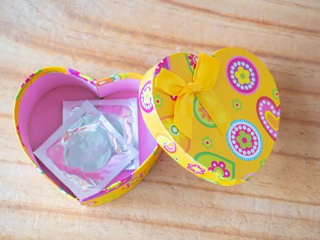 Boîte de coeur sur plancher en bois avec concept de préservatif